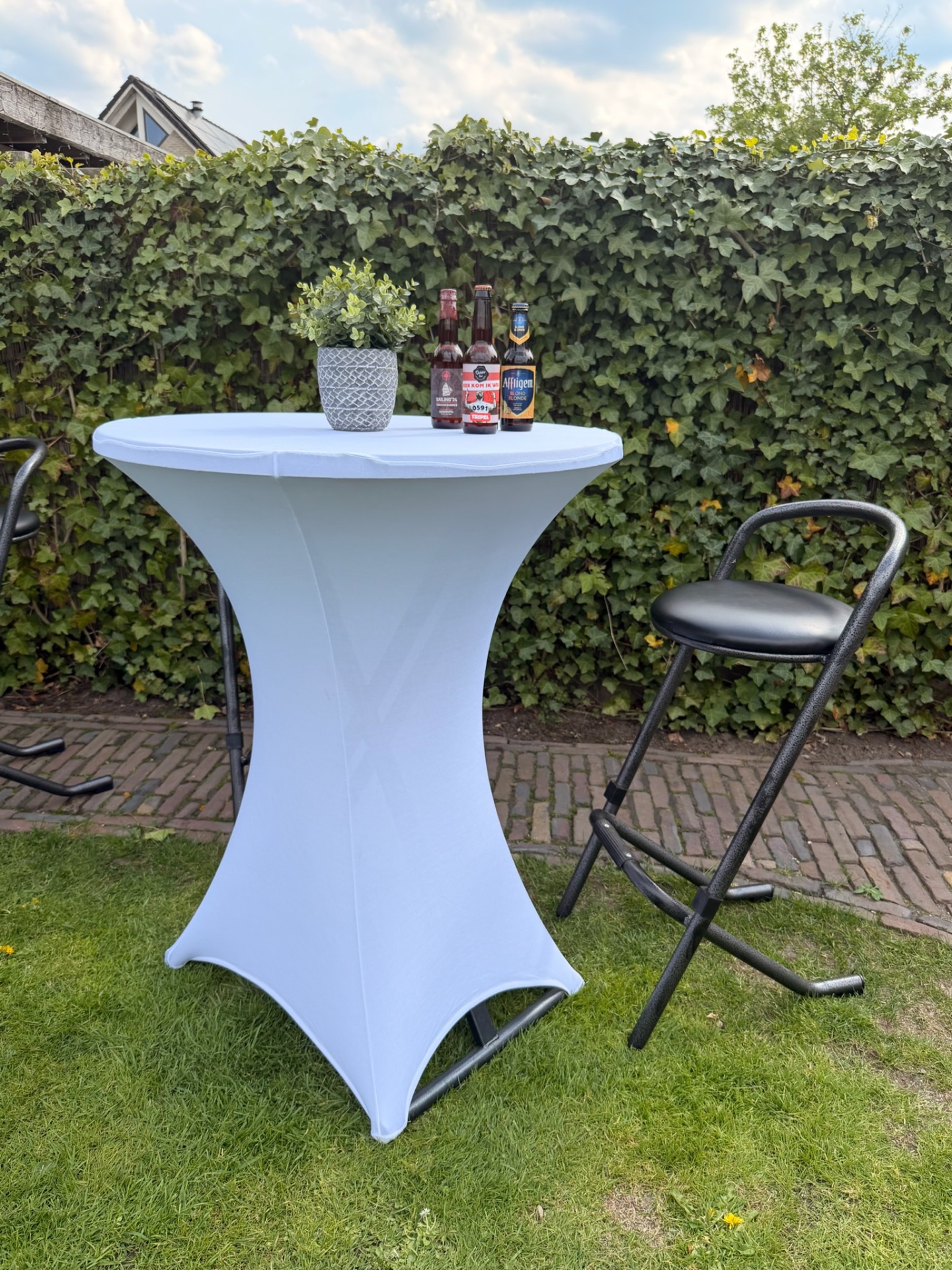 Statafel met witte rok en barkruk buiten