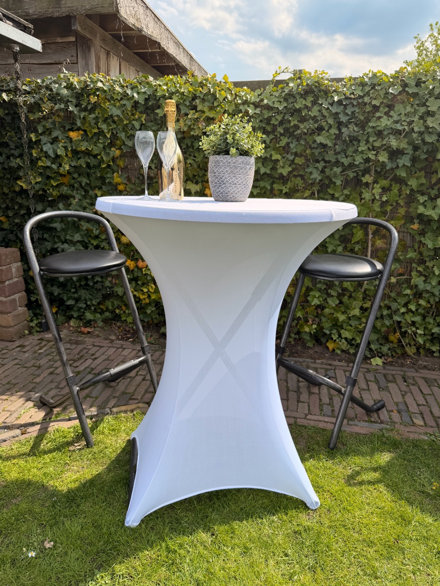 Statafel met witte rok, barkrukken en champagne